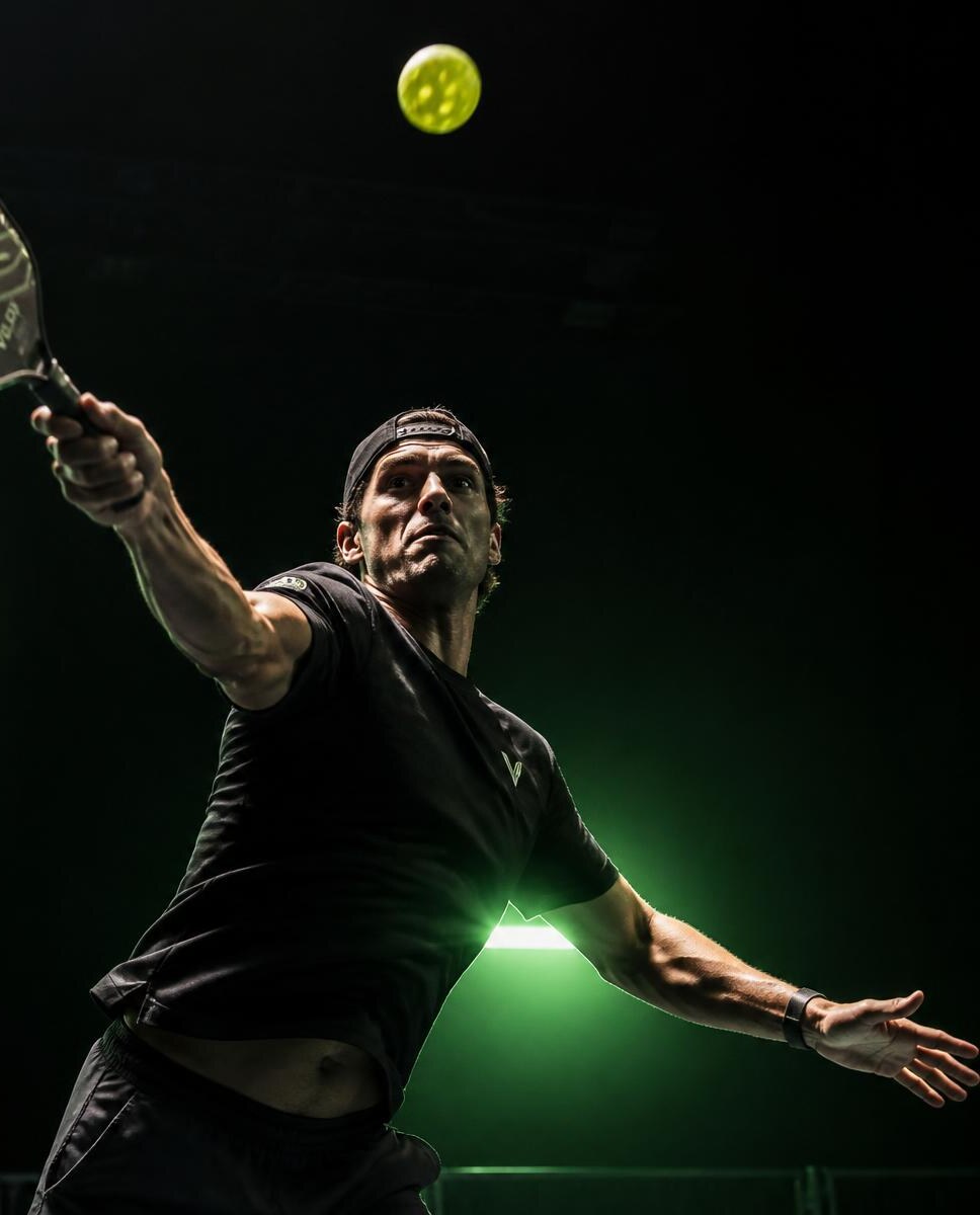 Pickleball player reaching for an overhead shot